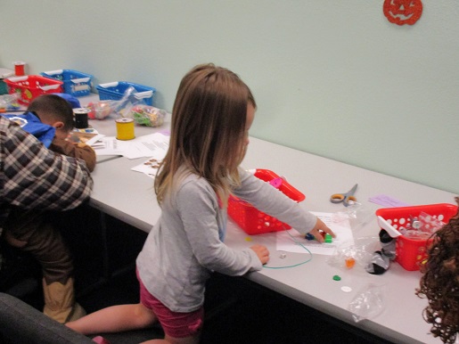 A little girl is making a story basket